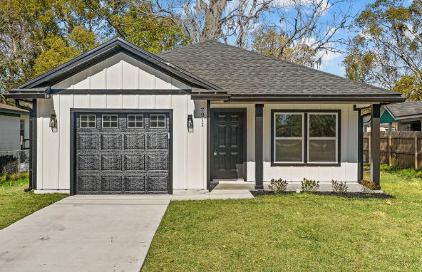Modern single-story home with white board-and-batten exterior, black trim and covered front porch