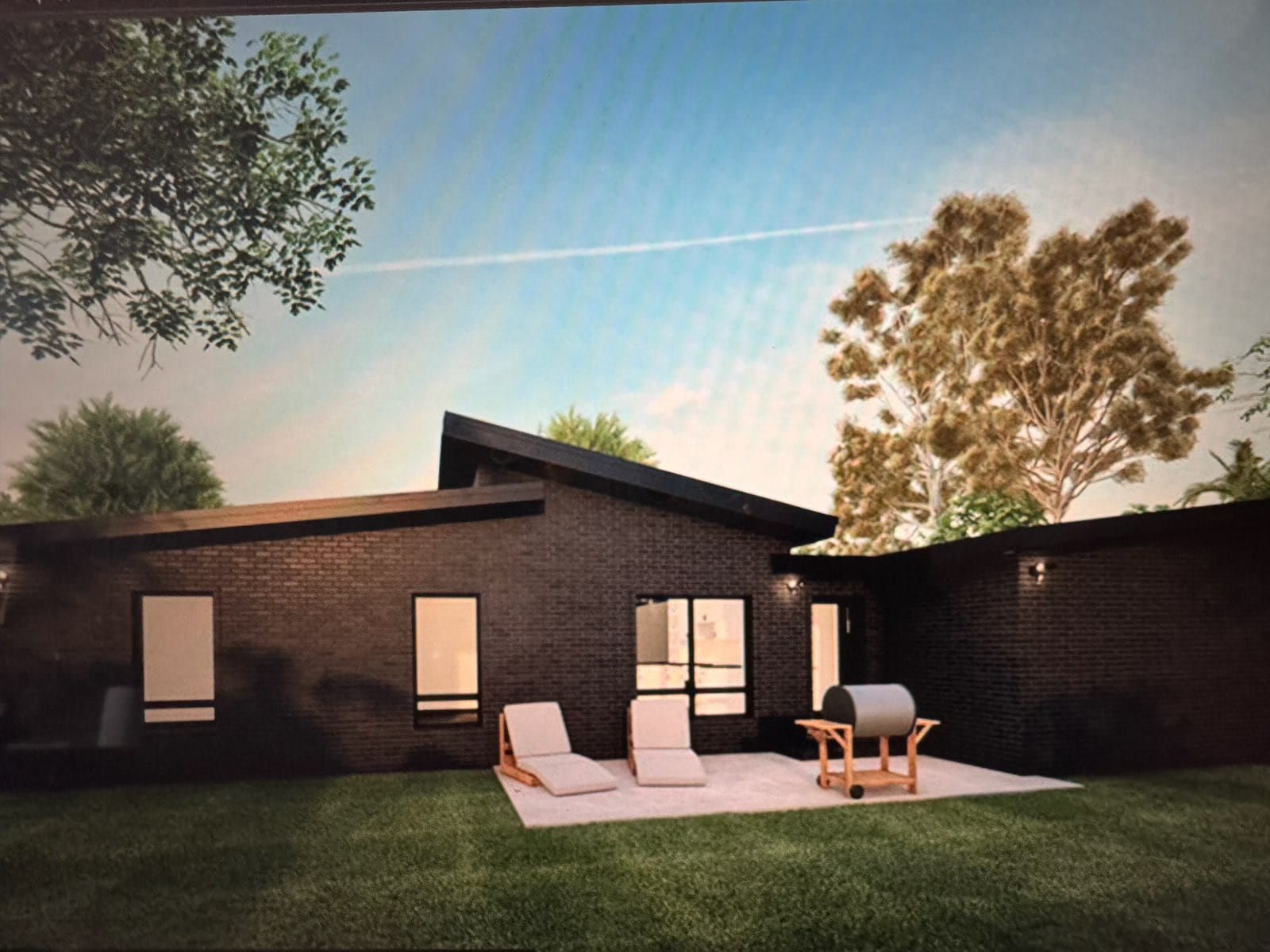 Rendering of the rear courtyard of the same TREV modern home with a concrete patio, lounge seating, and outdoor grill