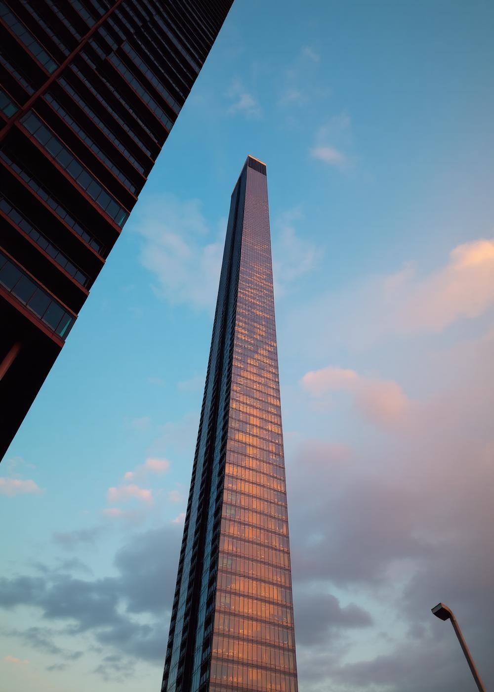 Modern residential tower reflecting dusk light